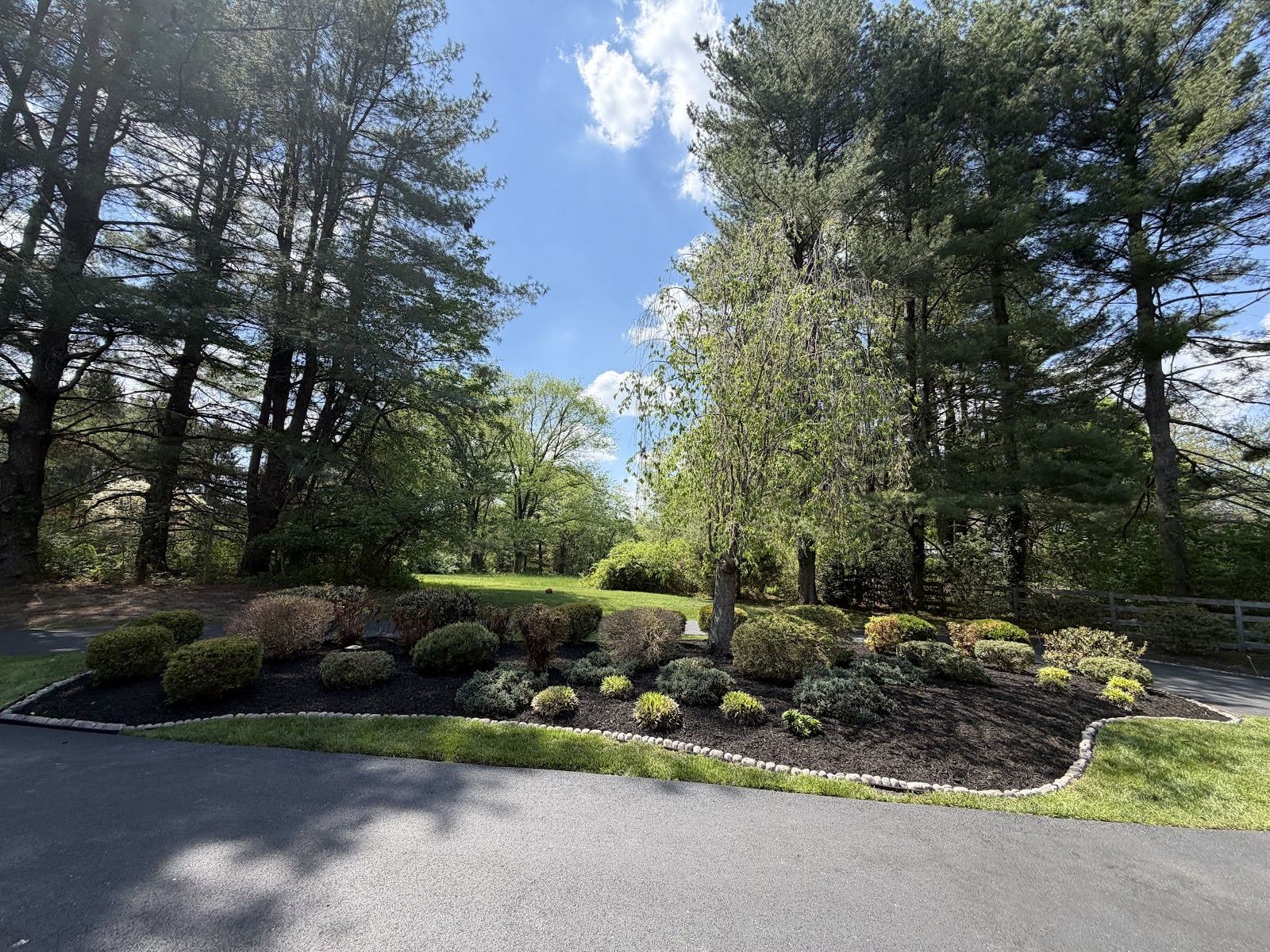 Corner island bed with shrubs and dark mulch — Green Diamond planting work